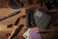 Close-up of lootable gear and crafted weapons laid out on a wooden table with blueprints.