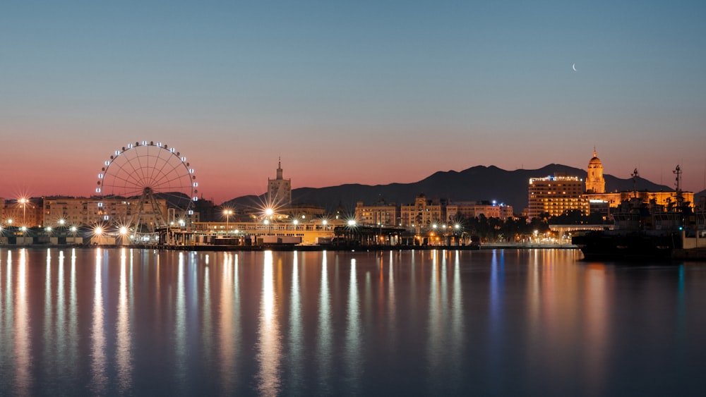 Horizonte de la ciudad cerca del cuerpo de agua durante la noche