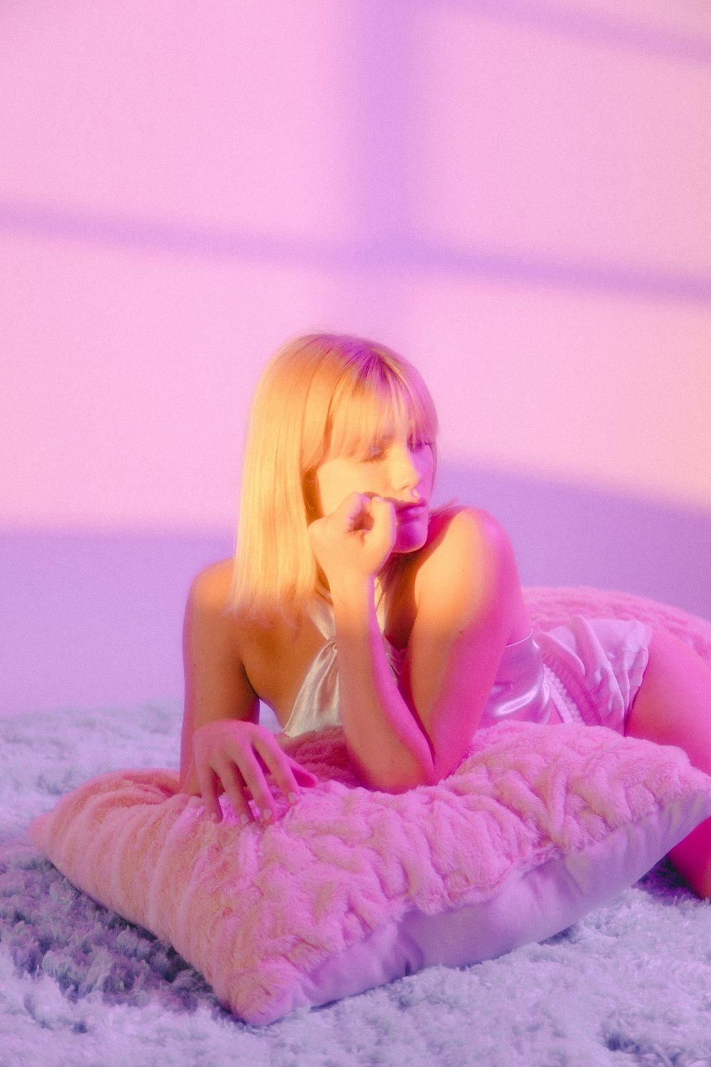 woman in pink tank top lying on bed