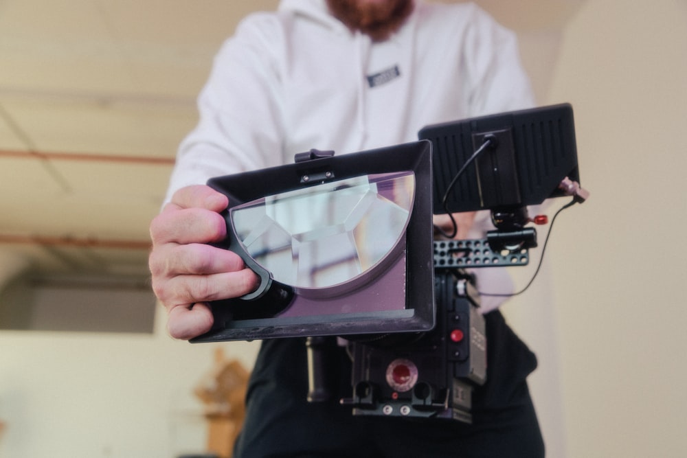 person holding black and silver camera