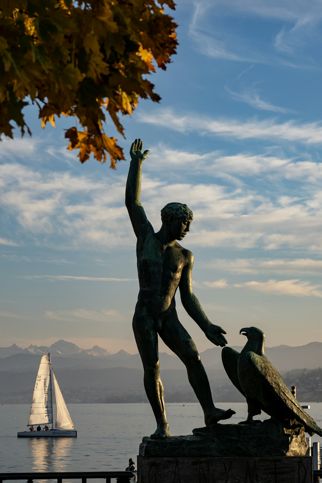 statue of man raising his right hand under blue sky during daytime