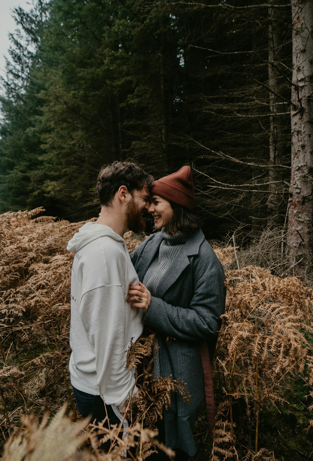 man and woman kissing on brown grass field during daytime