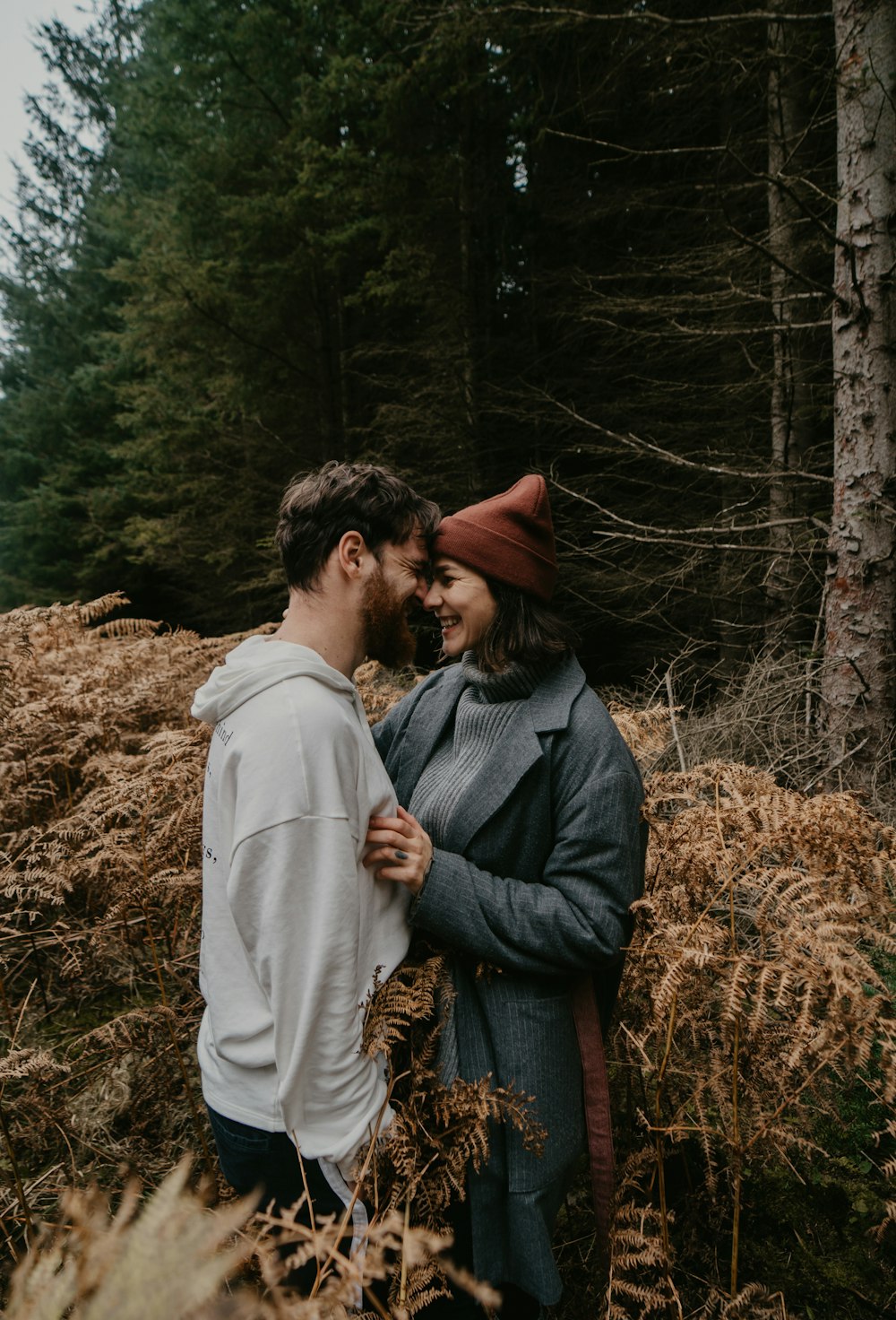 uomo e donna che si baciano sul campo di erba marrone durante il giorno