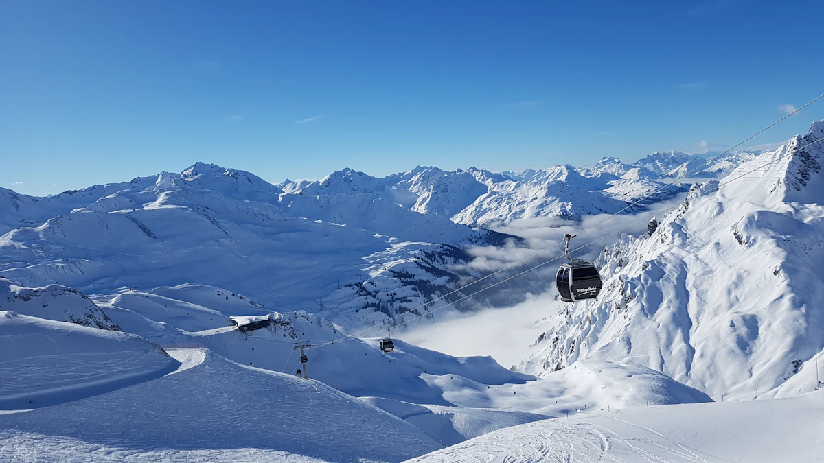 Snow covered Arlberg mountains under blue sky
