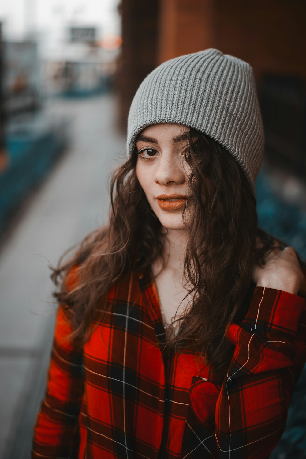 woman in red and black plaid jacket wearing gray knit cap