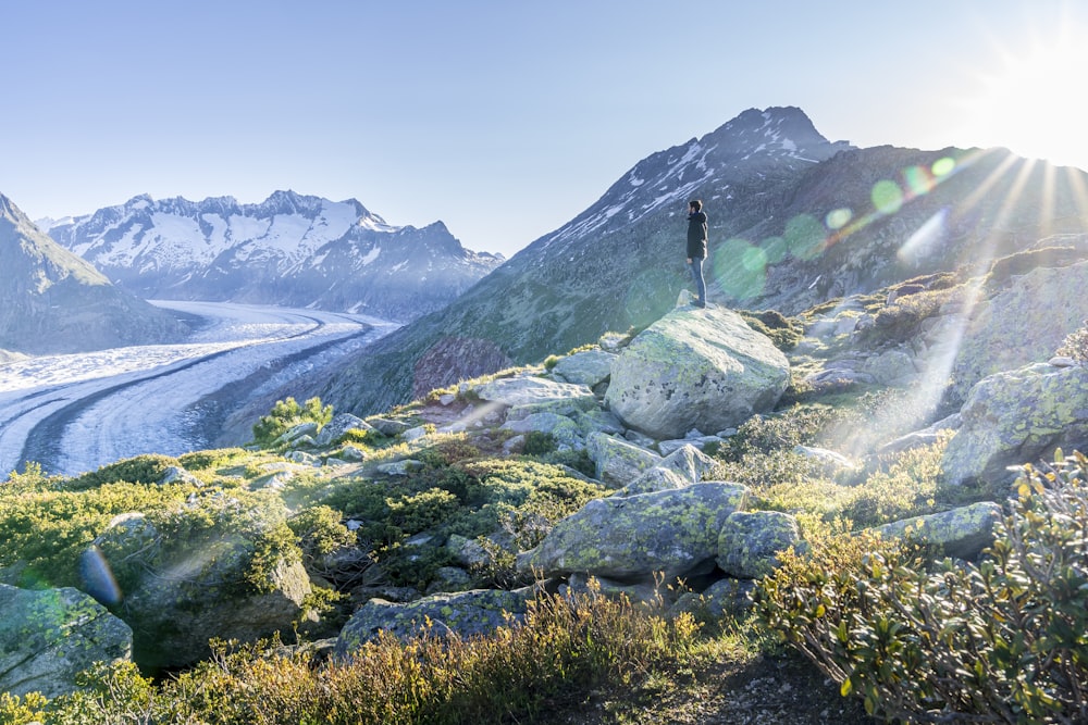 person standing on rock near mountain during daytime