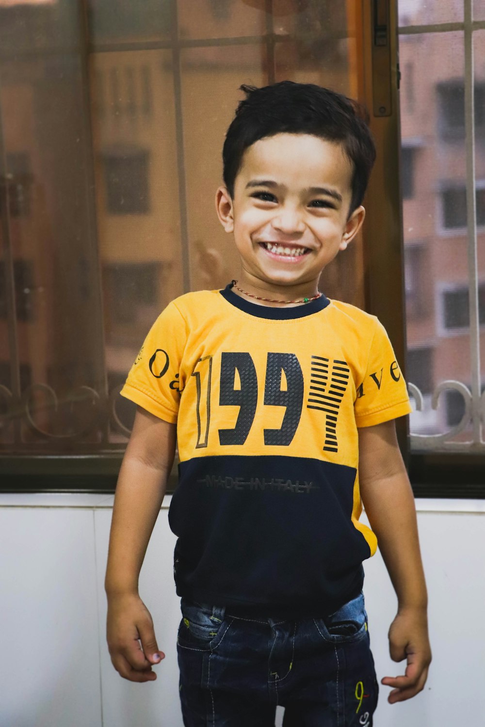 boy in yellow and black adidas crew neck t-shirt