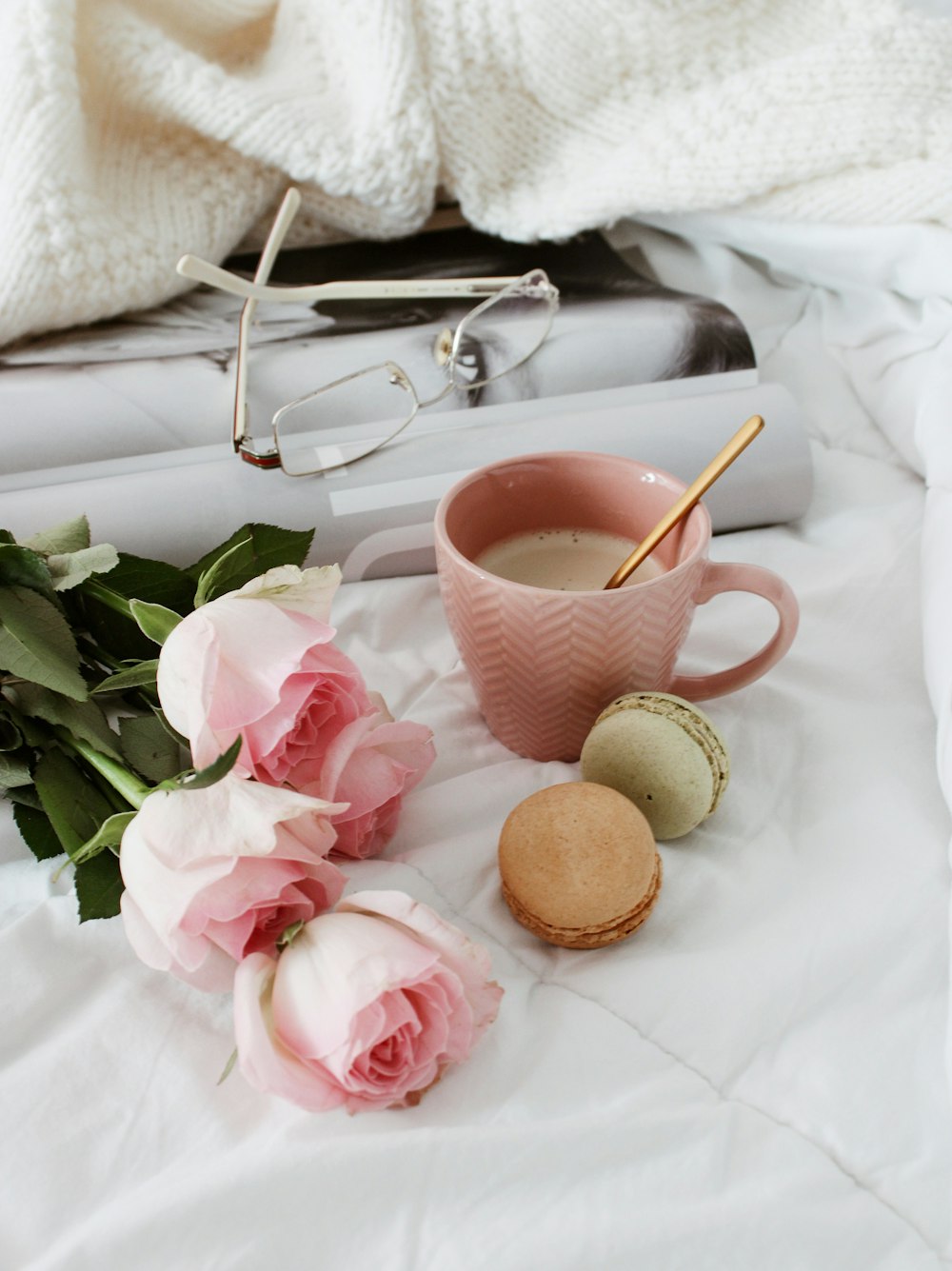 taza de té de cerámica rosa y blanca sobre tela blanca