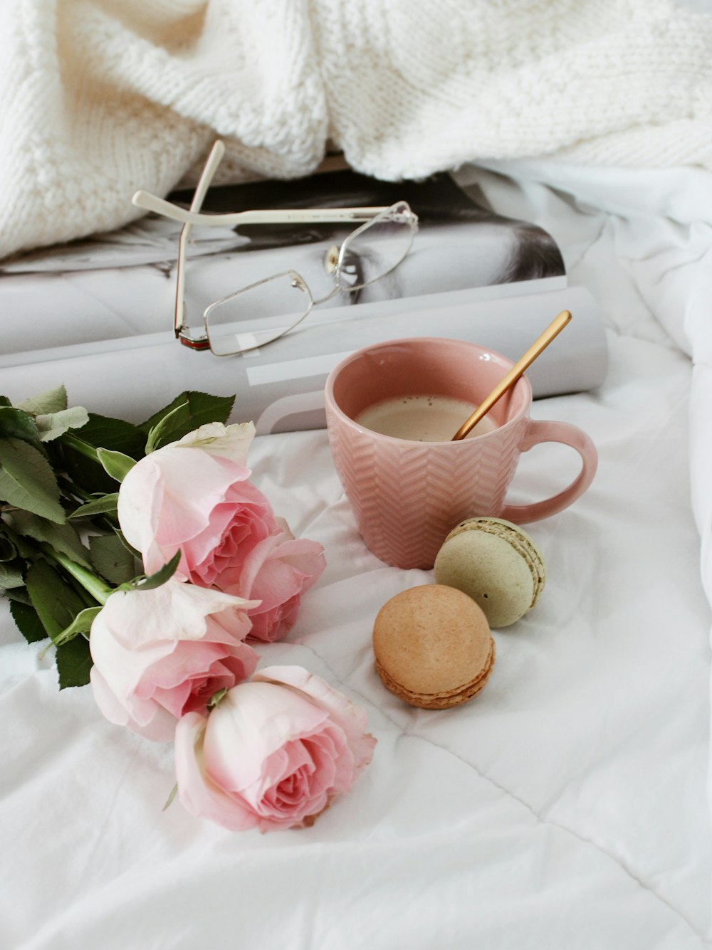 pink and white ceramic teacup on white textile