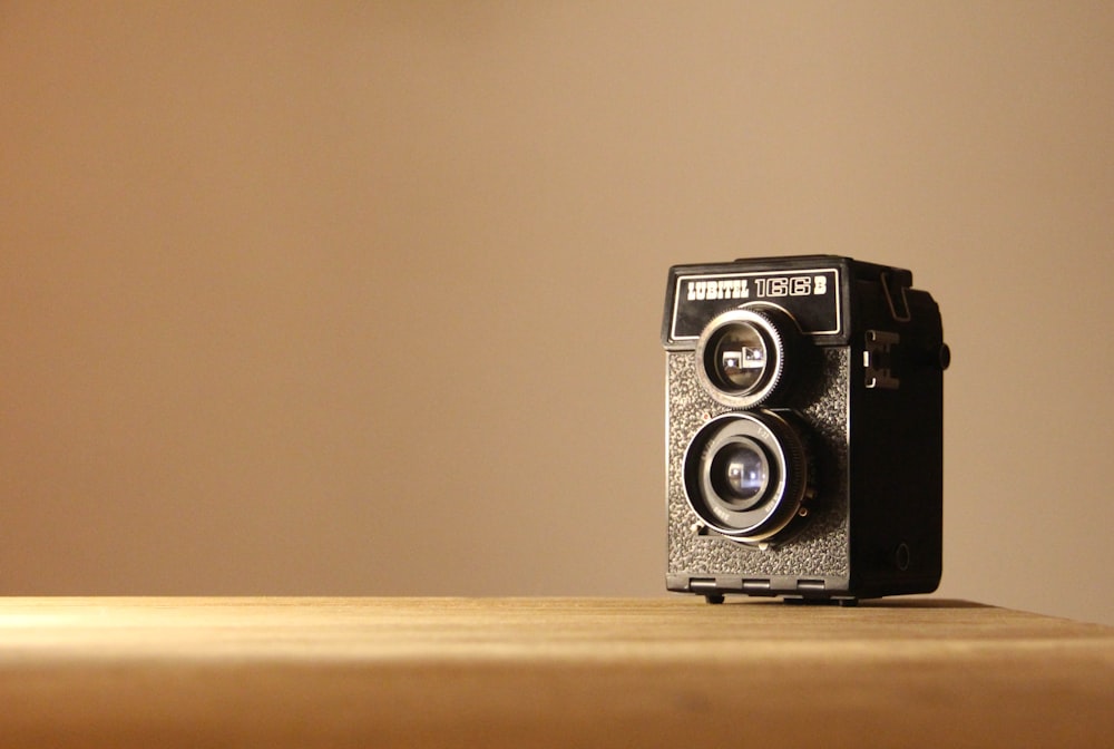 black and silver camera on brown wooden table