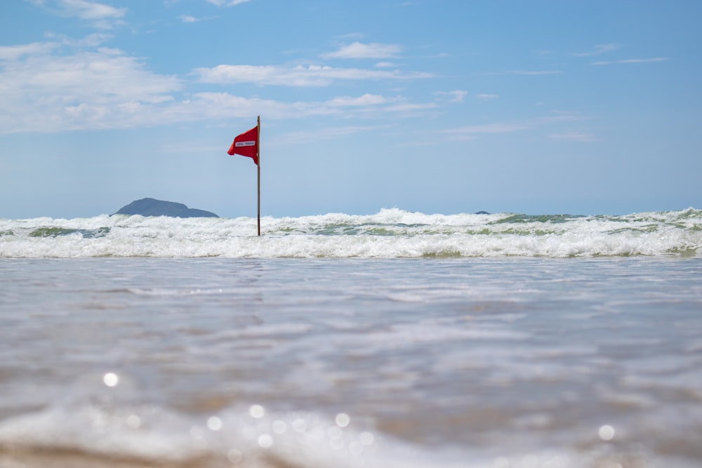 red and white flag on beach shore during daytime