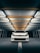 A white car is parked beneath an industrial ceiling with fluorescent lights illuminating the space. The vehicle is centered under a linear array of beams and lights, creating a focused and symmetrical perspective.