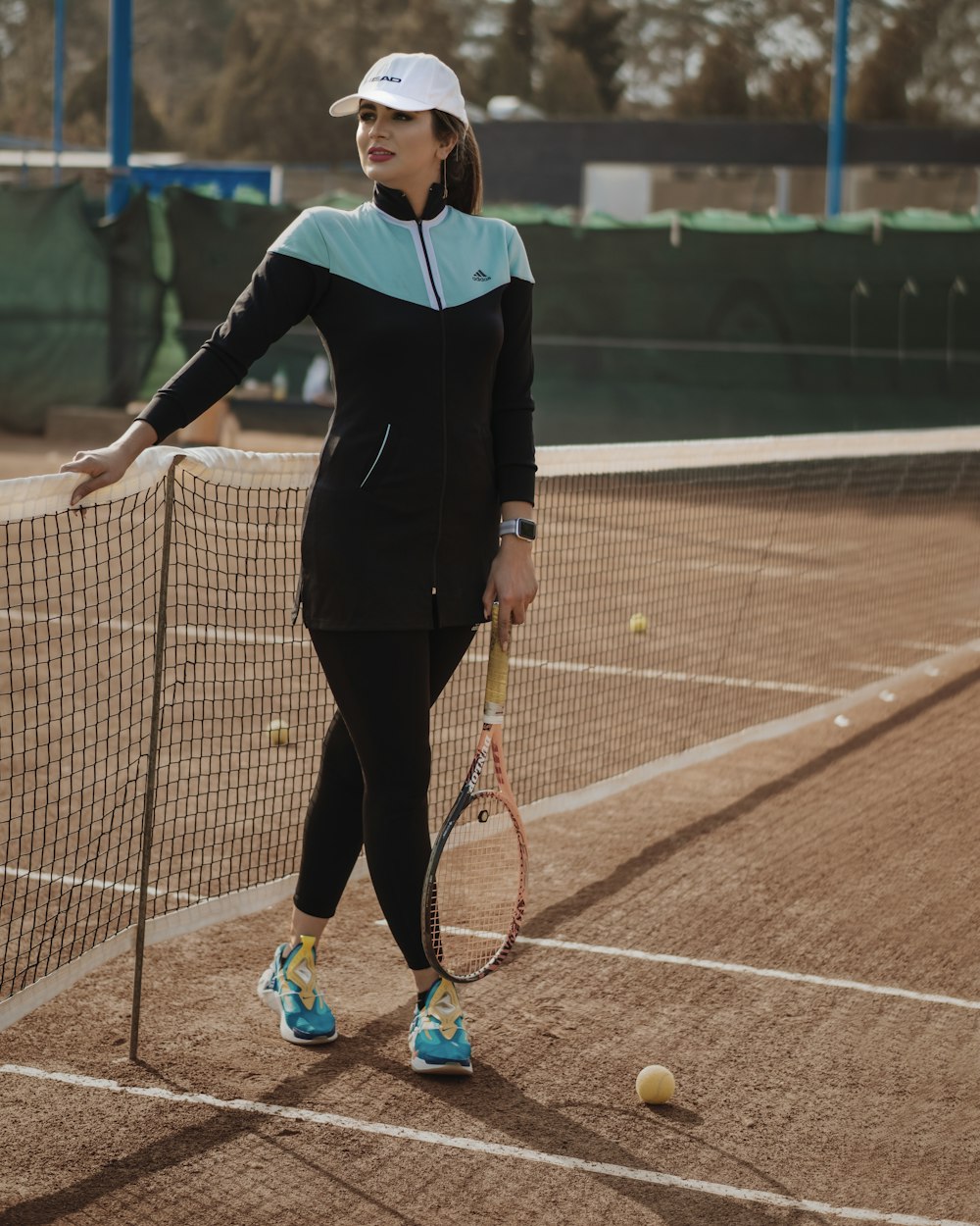 woman in black long sleeve shirt and black pants holding tennis racket