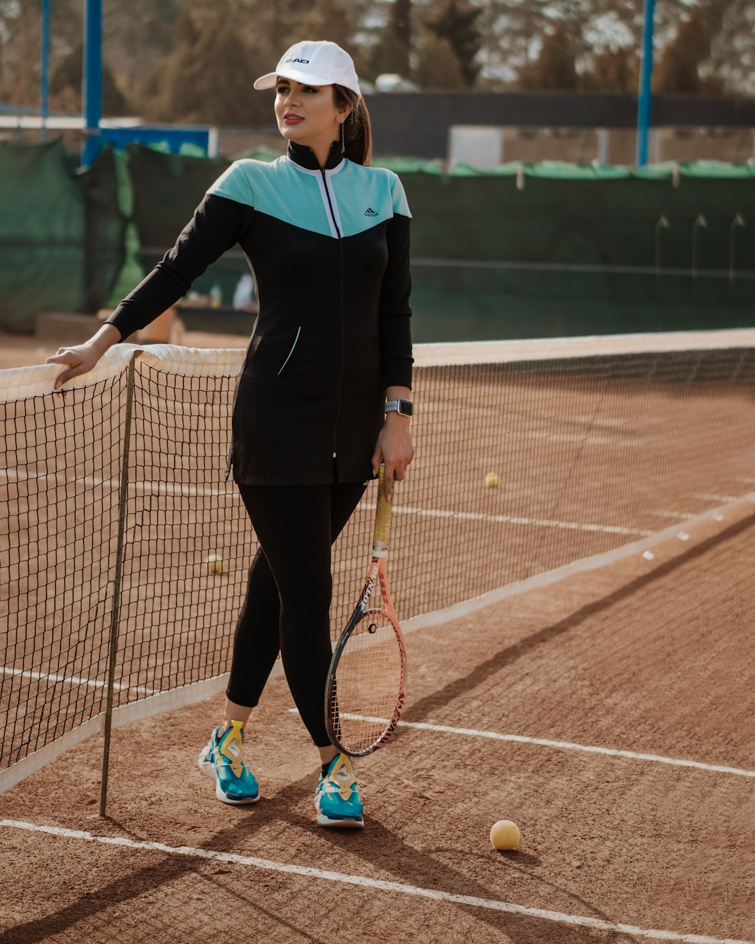 woman in black long sleeve shirt and black pants holding tennis racket