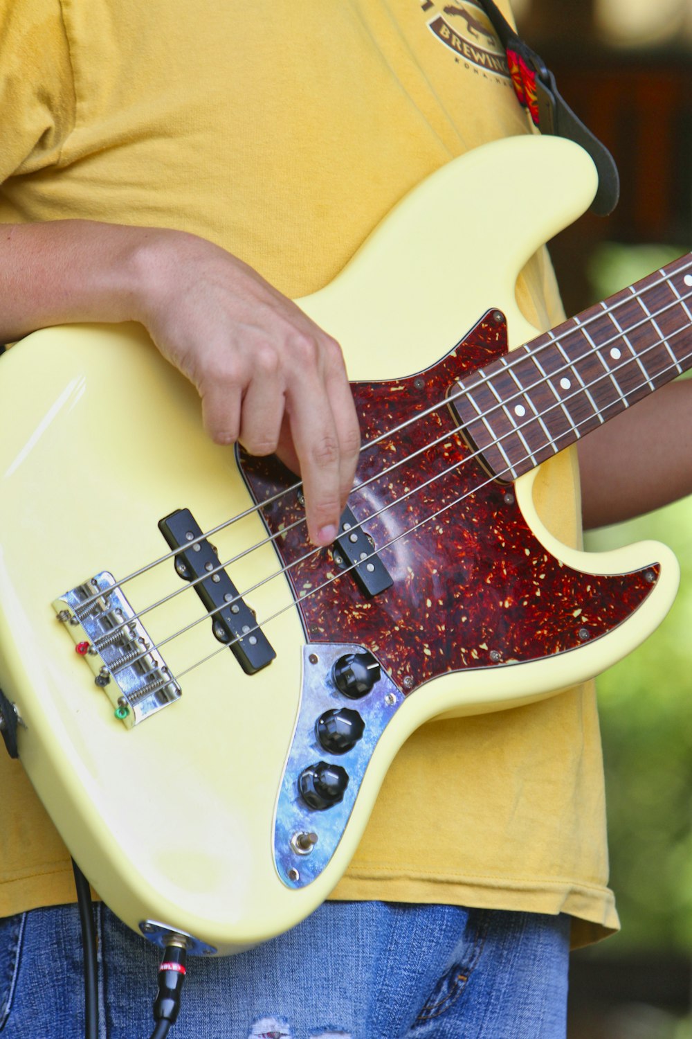 Persona tocando la guitarra eléctrica amarilla y roja