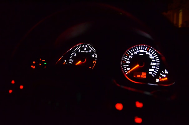 Close-up of a technician using diagnostic tools on a vehicle dashboard.