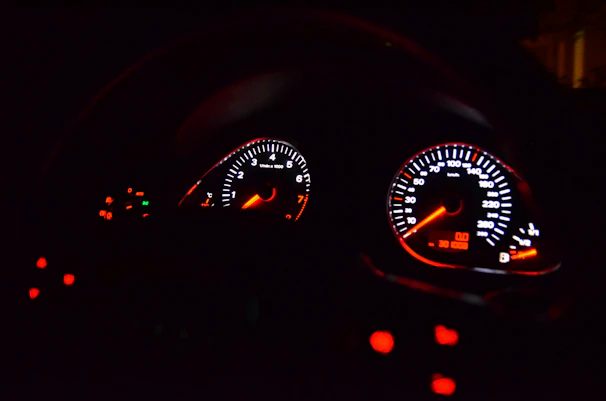 Close-up of a sleek Nissan Skyline GTR dashboard with Haltech tuning interface glowing red.