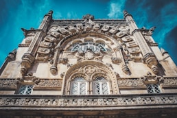 low angle photography of brown concrete building under blue sky during daytime