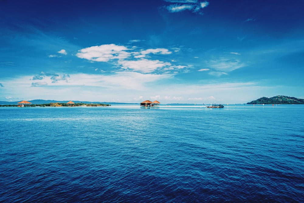 white and brown boat on sea under blue sky during daytime