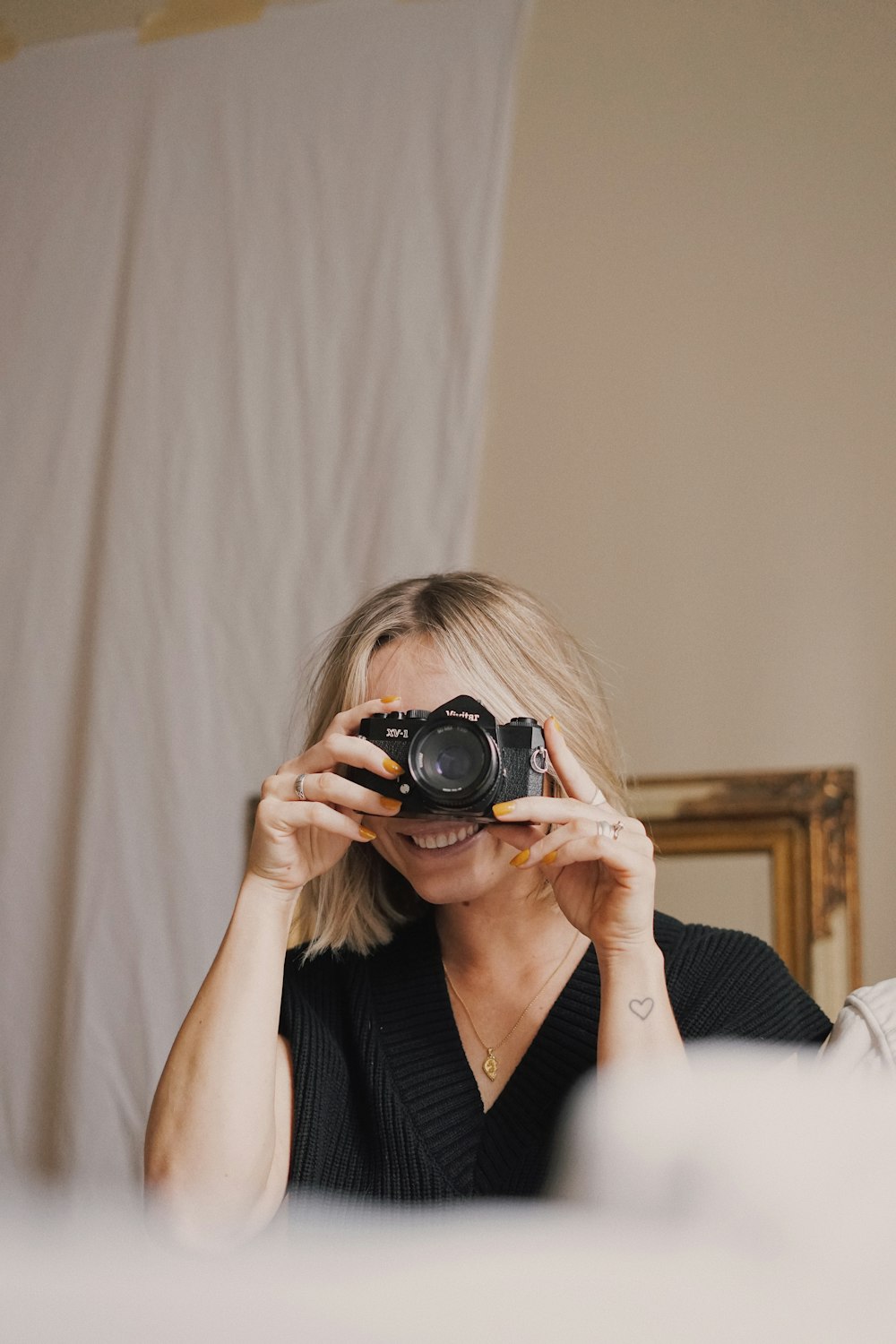 woman in black v neck shirt holding black dslr camera