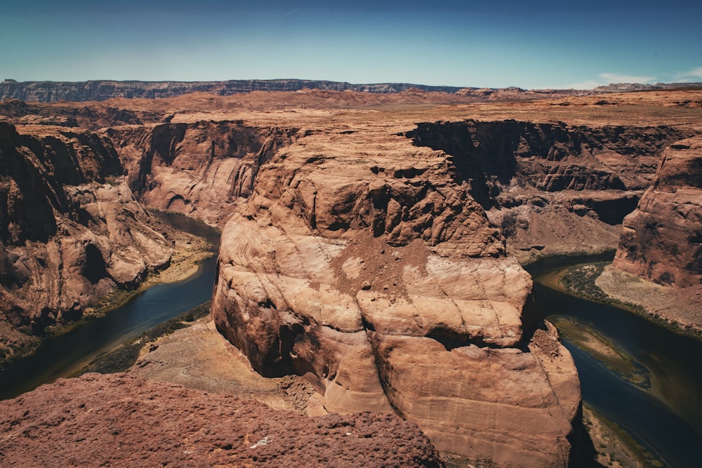 brown rock formation near body of water during daytime