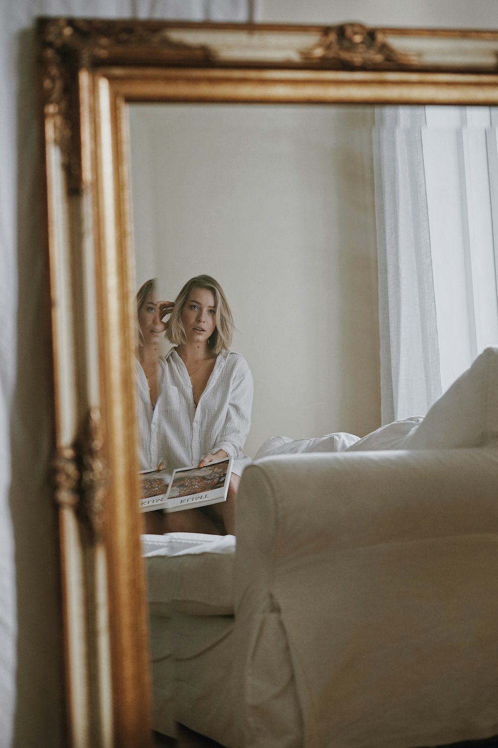 woman in white robe sitting on white couch