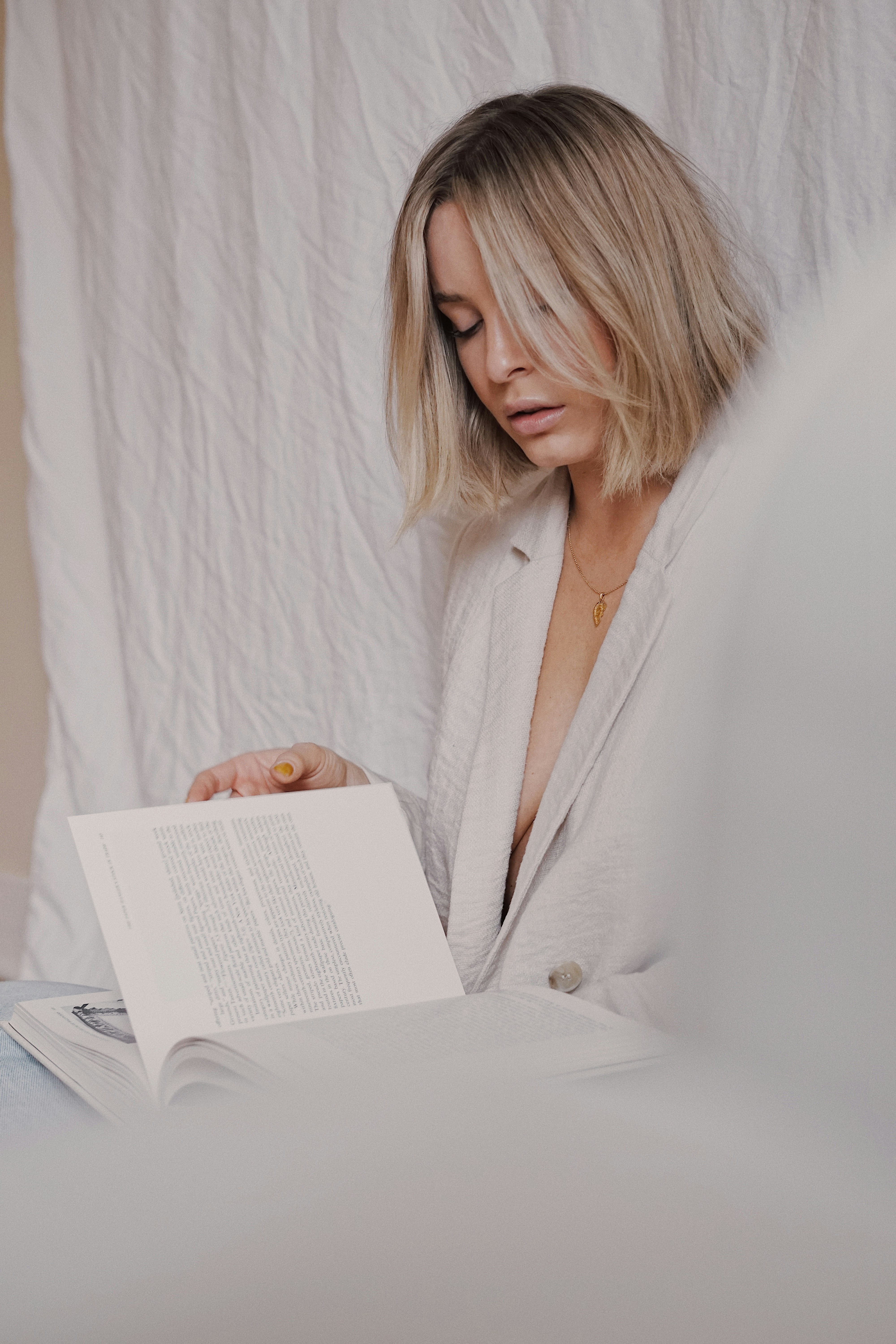 woman in white robe reading book