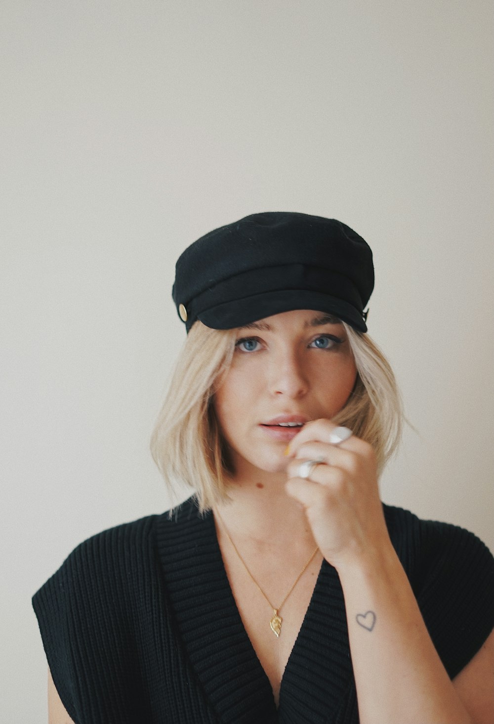 Mujer con gorra de punto negra y cárdigan negro