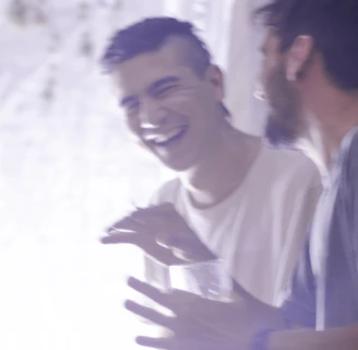 A candid moment of laughter between a Vitalis agent and a client during a friendly meeting.