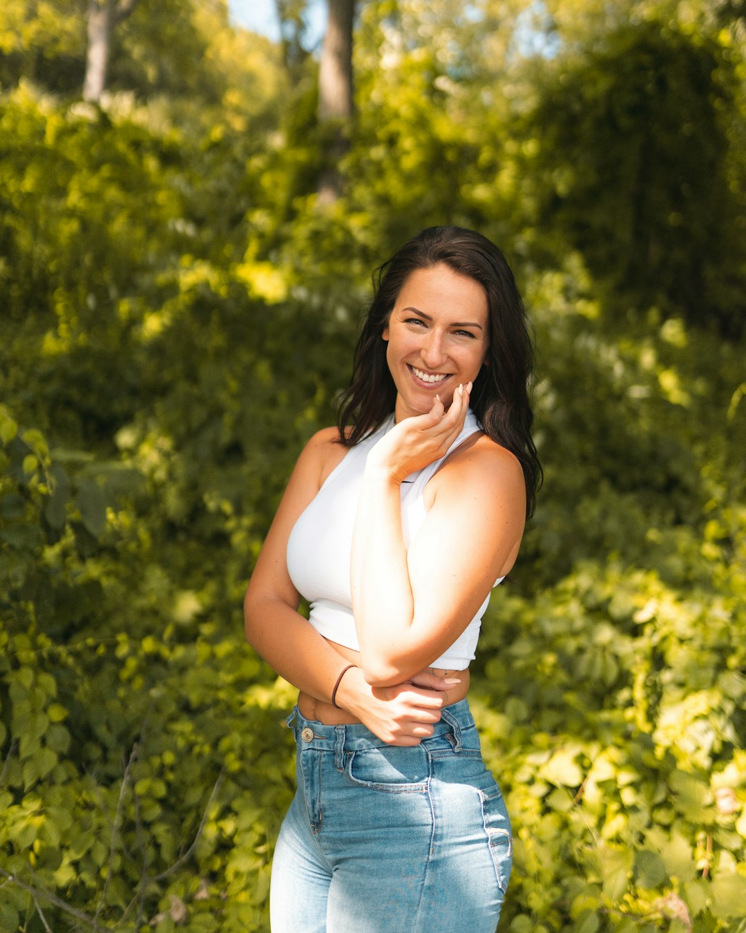 woman in white tank top and blue denim shorts smiling