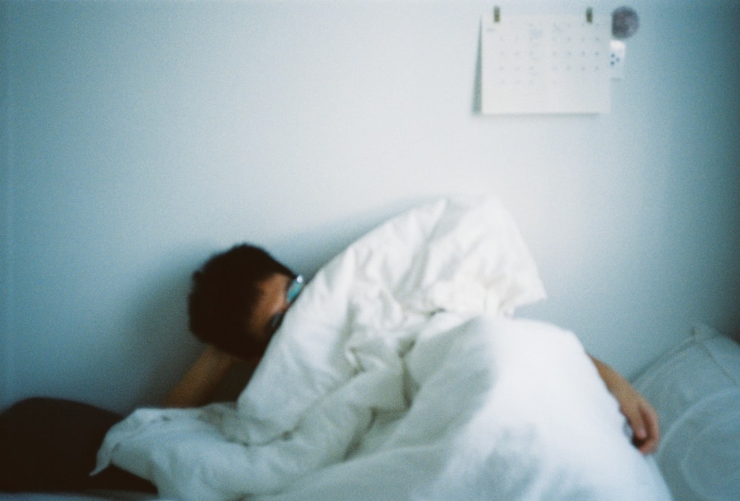 A person waking up tired, looking at the clock after a restless night