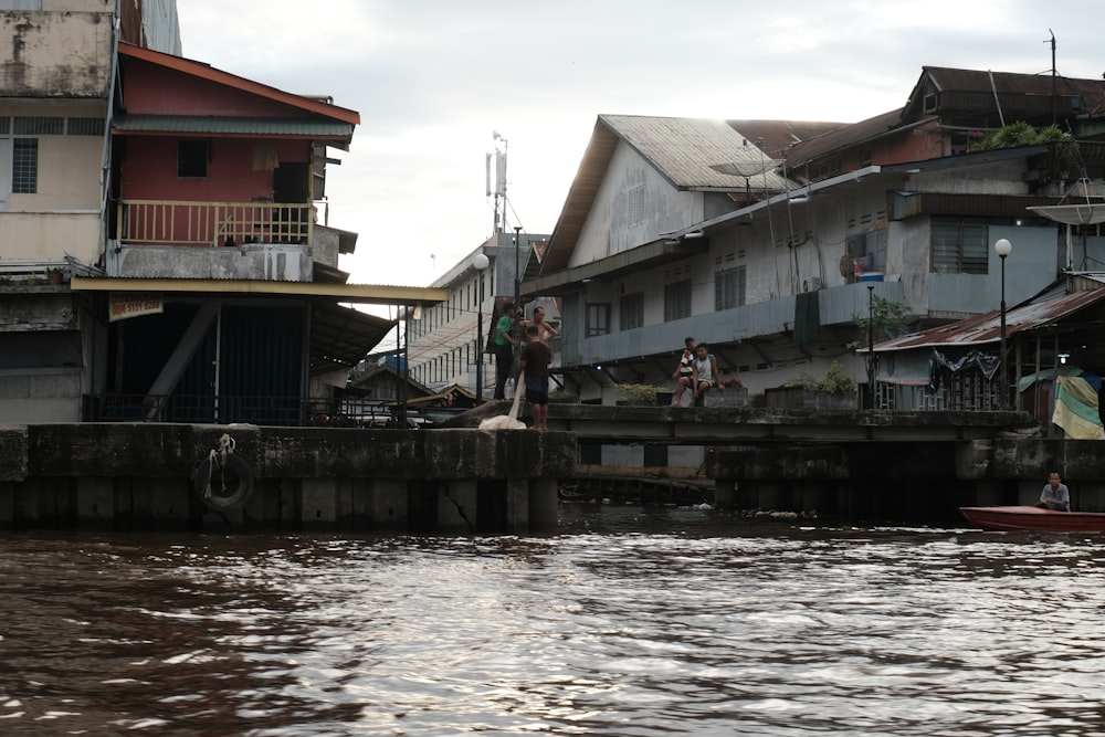 people walking on bridge near houses during daytime