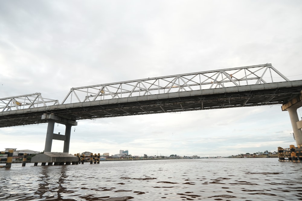 ponte in acciaio grigio sullo specchio d'acqua durante il giorno