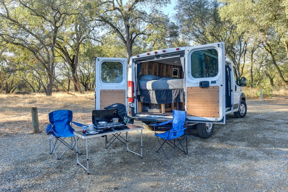 blue and black camping chair beside brown wooden door