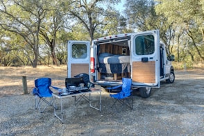 blue and black camping chair beside brown wooden door