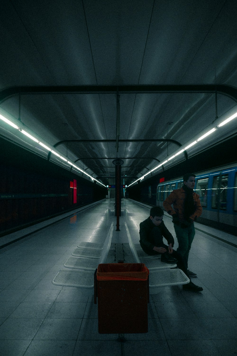 man in black jacket walking on train station