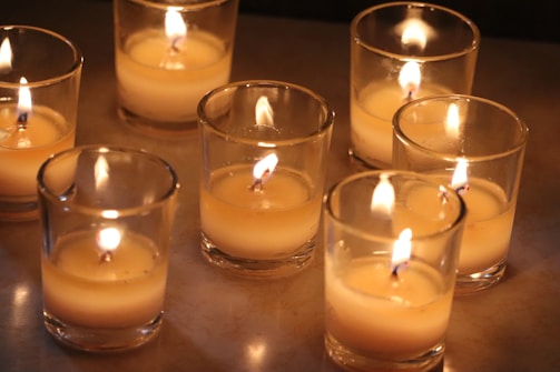 A collection of homemade candles glowing softly in a cozy setting.
