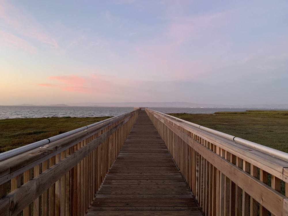 brown wooden bridge under cloudy sky during daytime