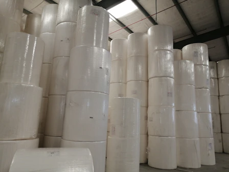 Photo of stacked rolls of BOPP tapes and stretch films in a warehouse.
