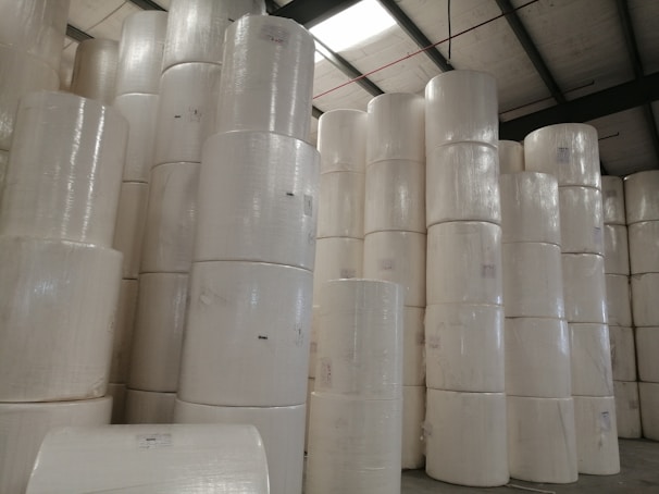 Rolls of thermal labels and thermal paper stacked ready for sale.