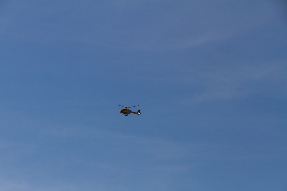 black helicopter flying in the sky during daytime
