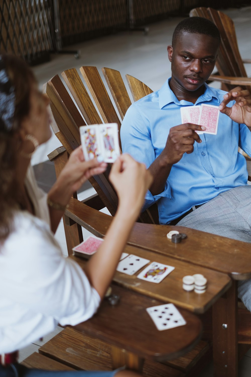 파란색 버튼 업 셔츠를 입은 남자가 카드 놀이를 들고 있다