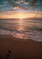 ocean waves crashing on shore during sunset