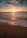 ocean waves crashing on shore during sunset