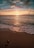 ocean waves crashing on shore during sunset