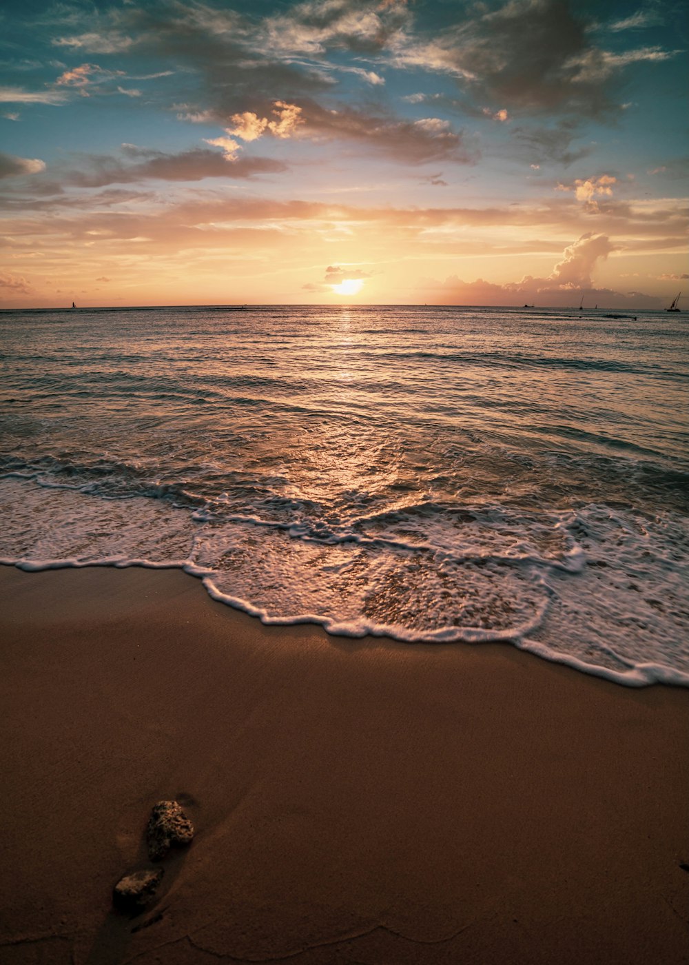 ocean waves crashing on shore during sunset