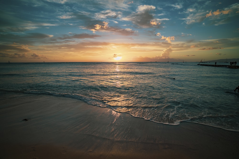 ocean waves crashing on shore during sunset