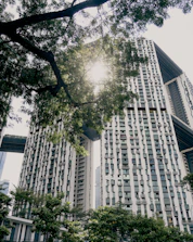 Modern eco-friendly buildings surrounded by green spaces and sunlight.