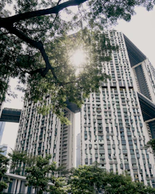 Modern eco-friendly buildings surrounded by green spaces and sunlight.