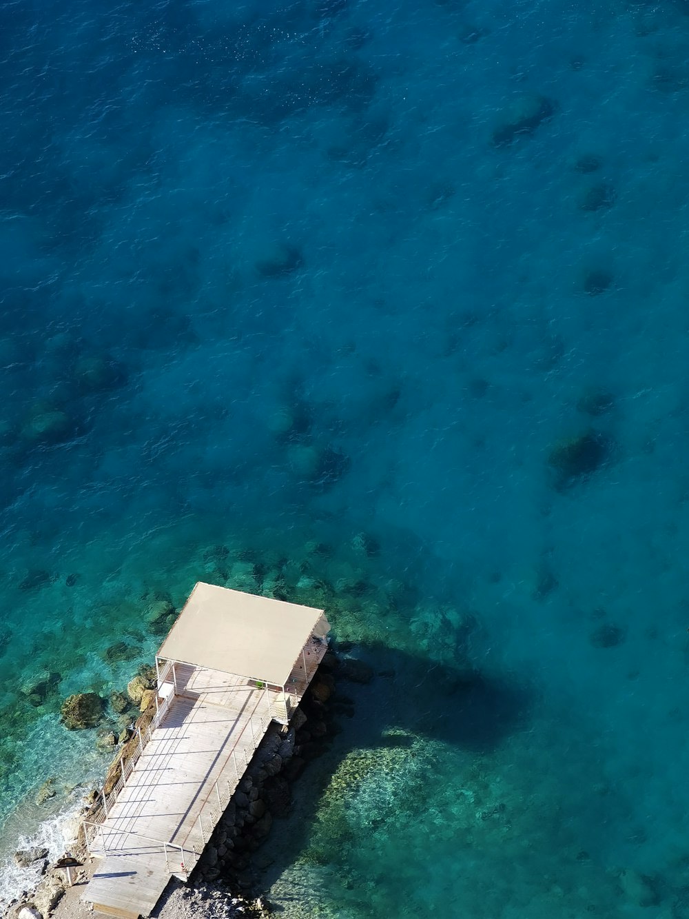 aerial view of white and brown wooden house on beach during daytime